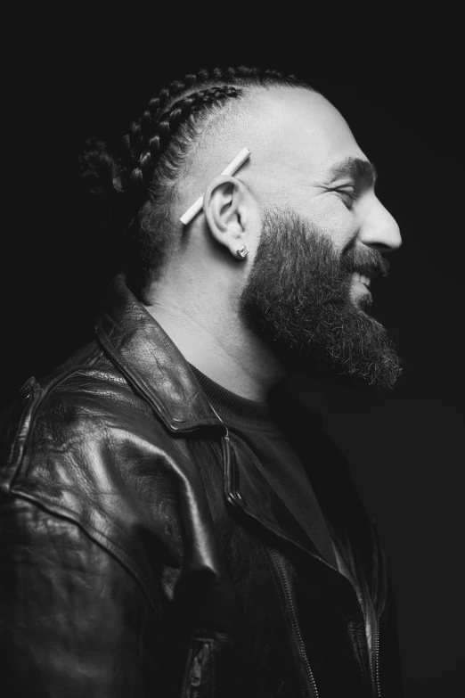 a black and white image of a man wearing a leather jacket