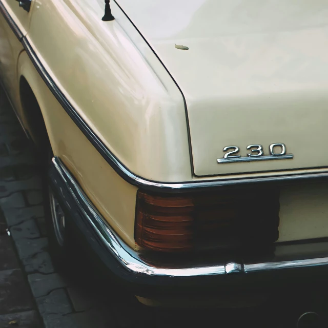 a very nice old looking white car on a road