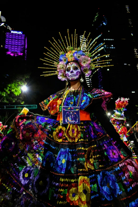 a woman dressed up like a mexican dancer in front of a crowd