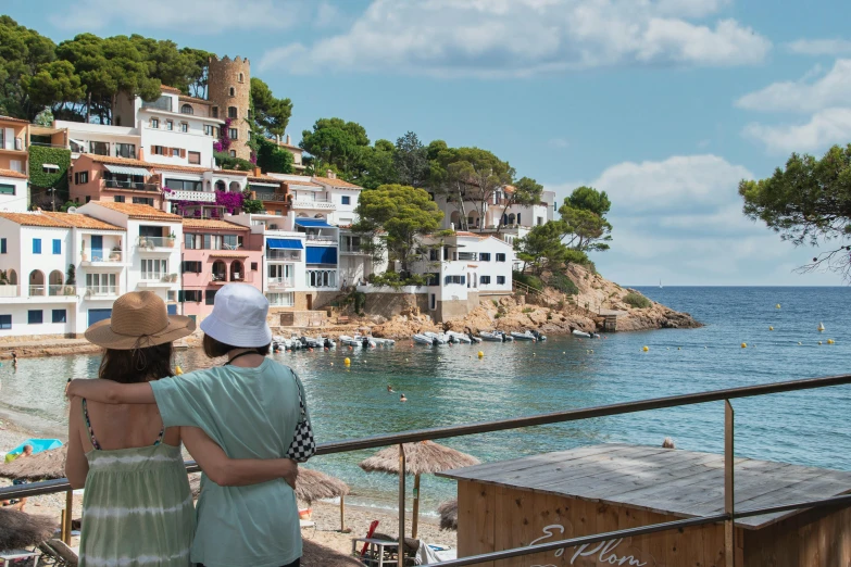 a couple standing on top of a pier next to the ocean