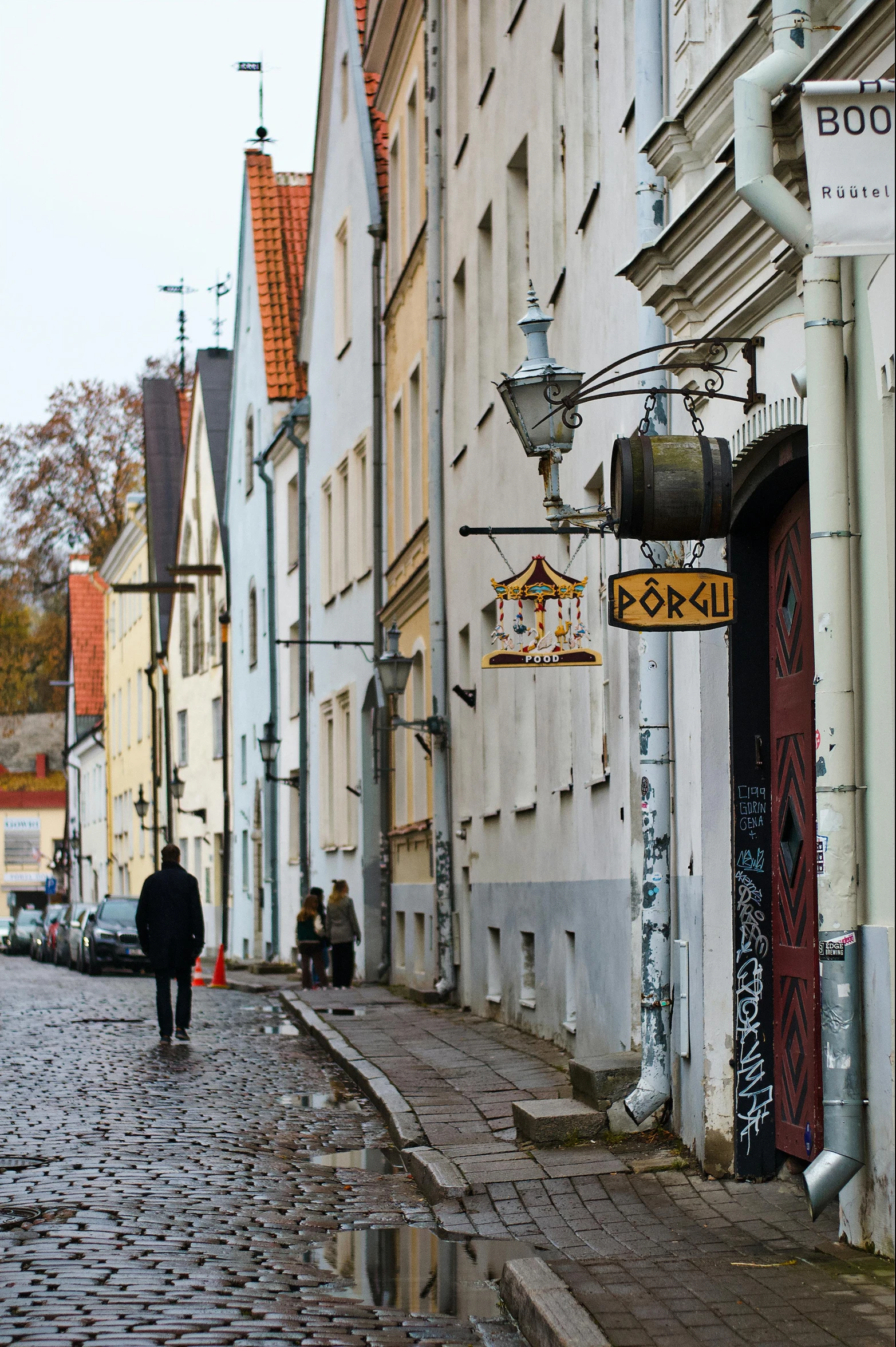 people are walking down the cobblestones on a city street