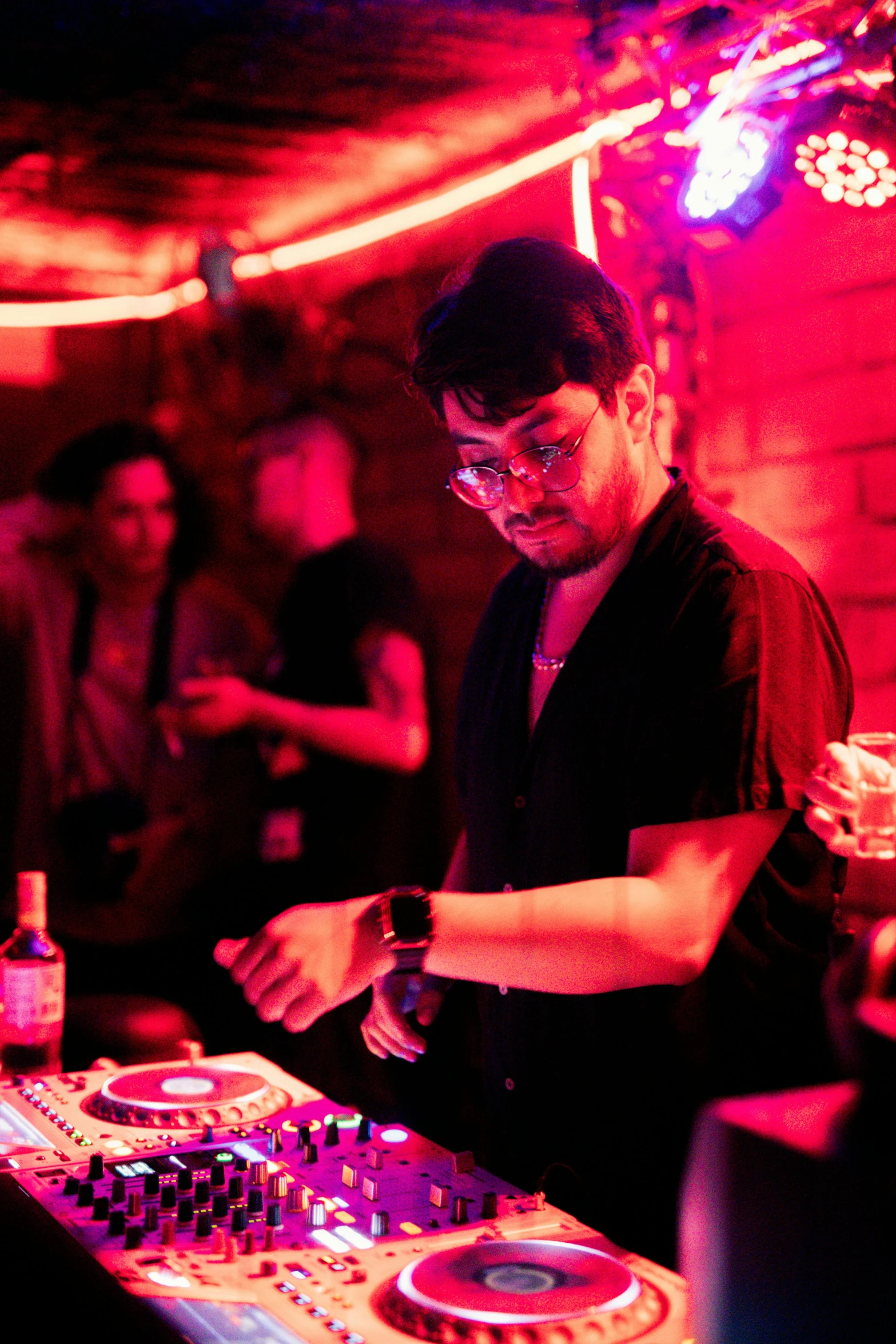 a dj mixing music in front of a crowd at night