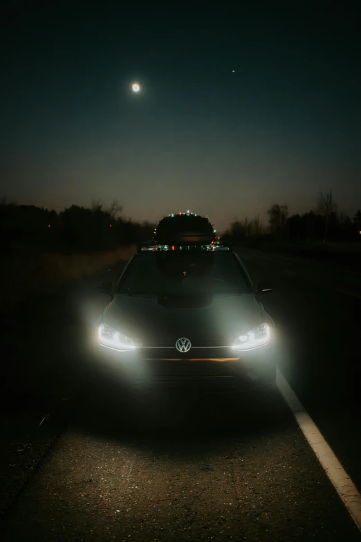 an approaching car on a road at night with bright headlights