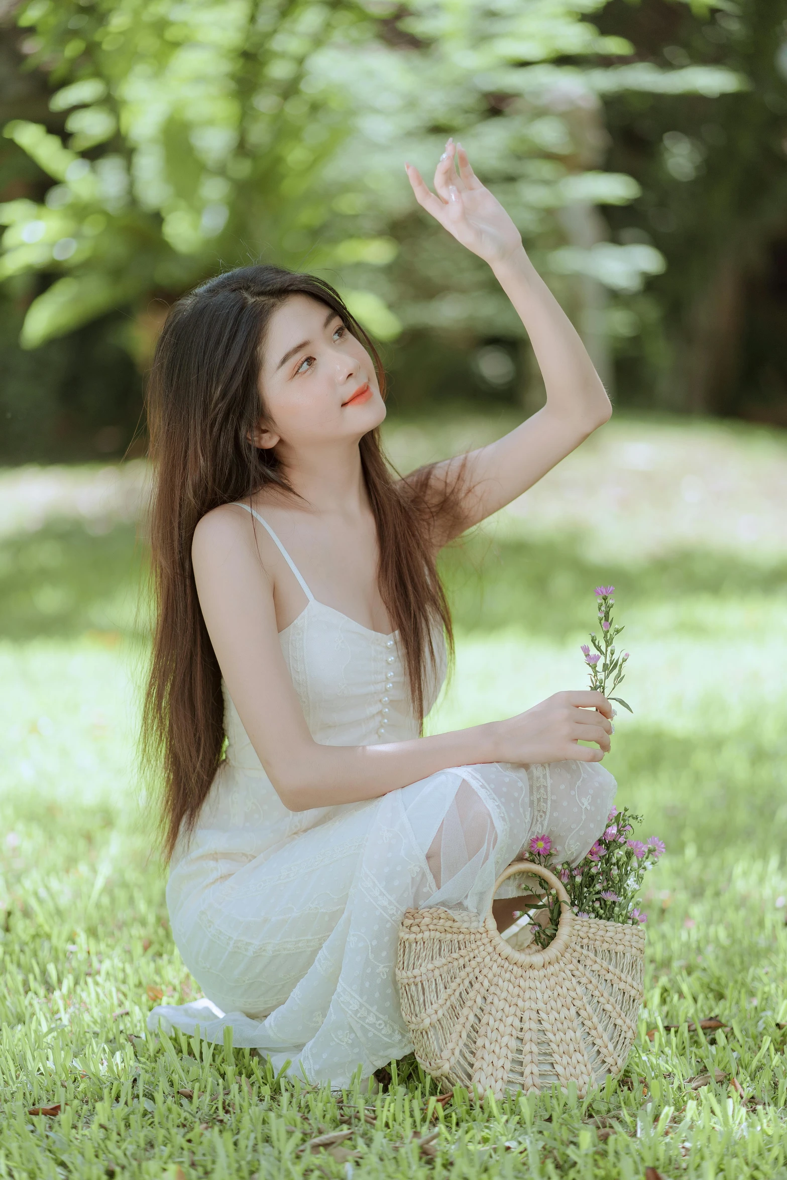 asian girl kneeling on the ground in the grass