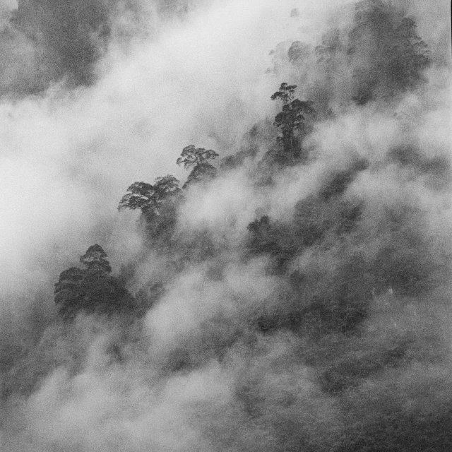 a view of mountains from the air, clouds over them