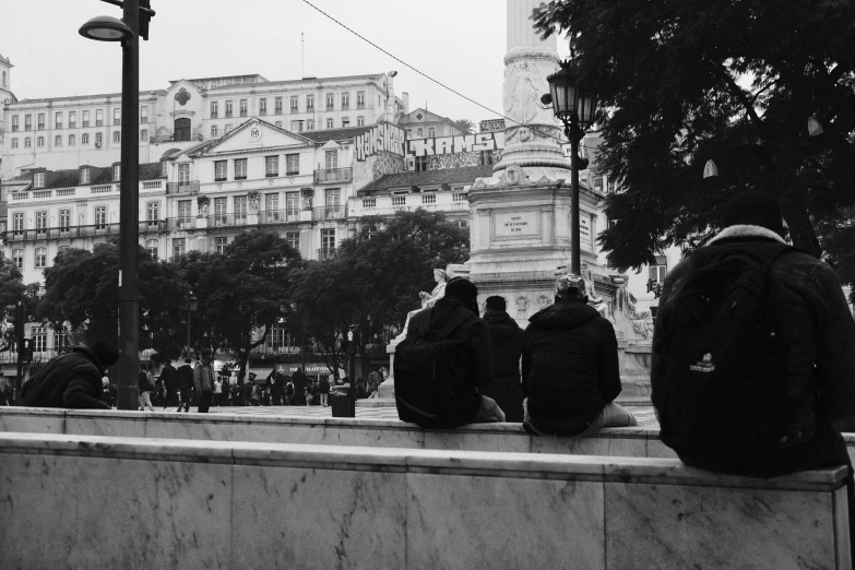 two men sitting in the middle of a wall