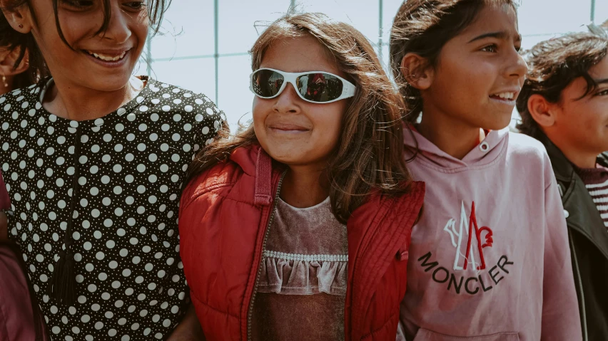 two children standing next to each other wearing sun glasses