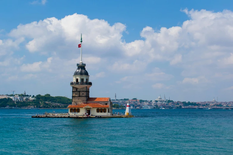 the lighthouse has a flag on it on a pole