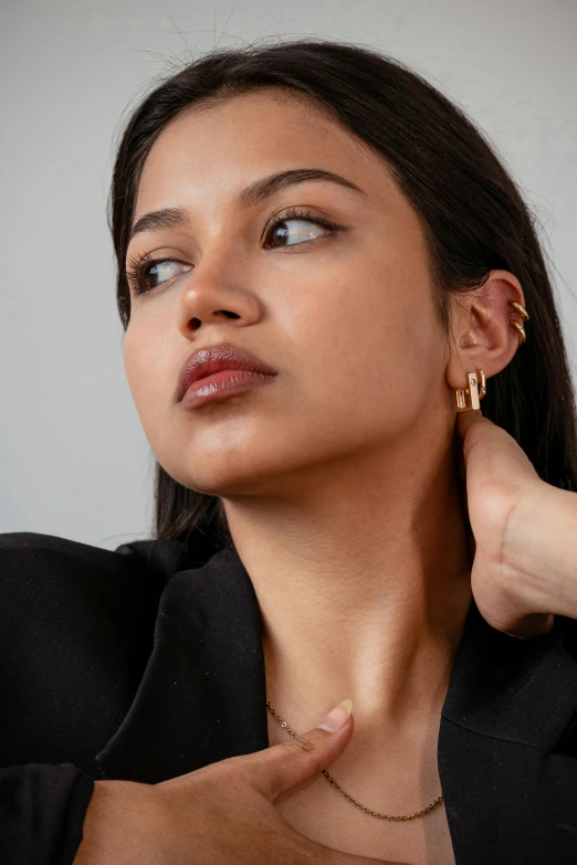 young woman in black shirt with golden earrings