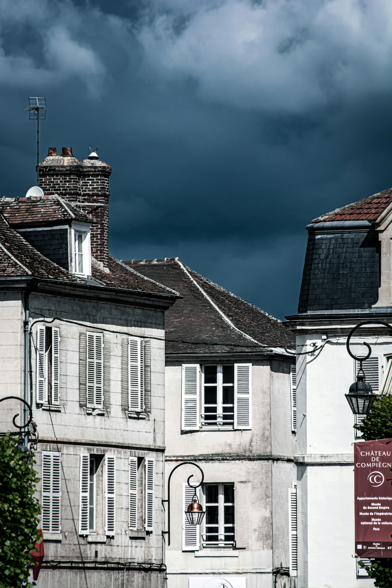 whitewashed and shuttered buildings on a dark cloudy day