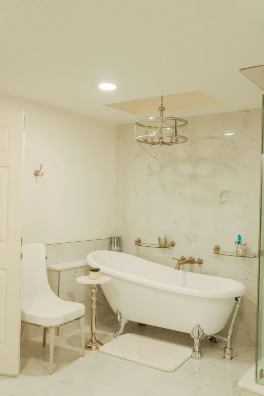 the interior of a bathroom with marble tile and a white claw foot bathtub