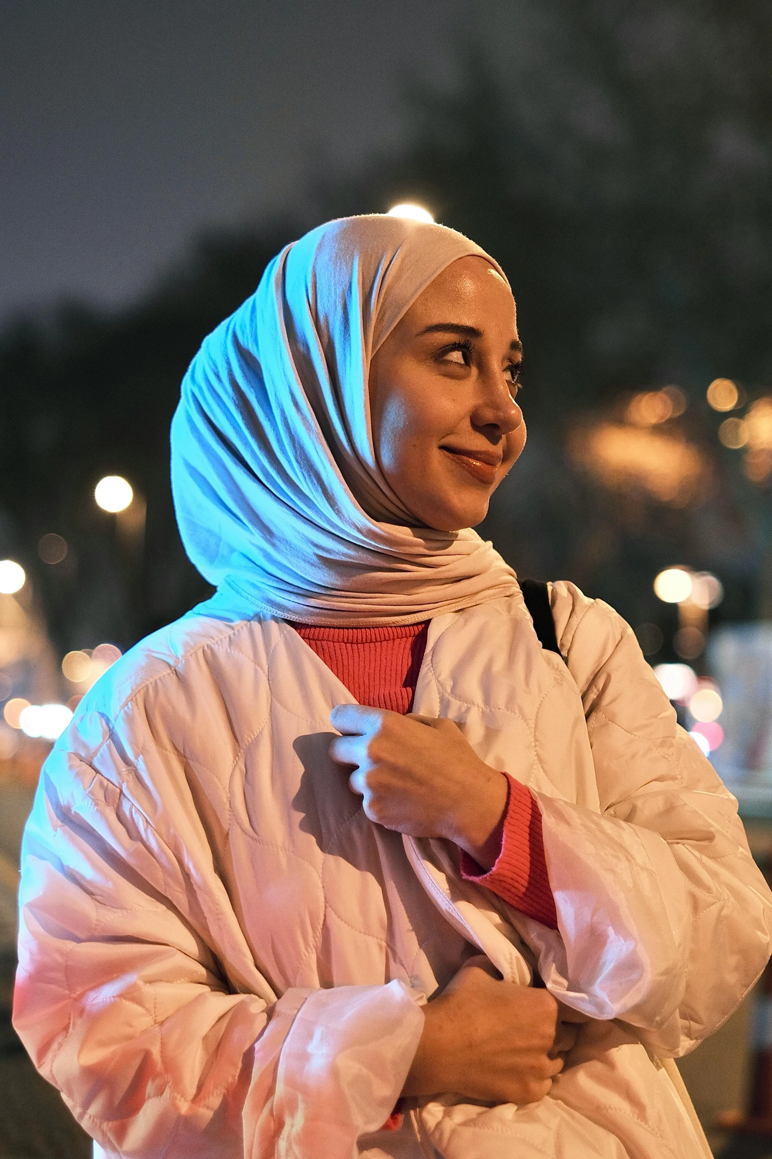 a woman with a white head scarf looking up