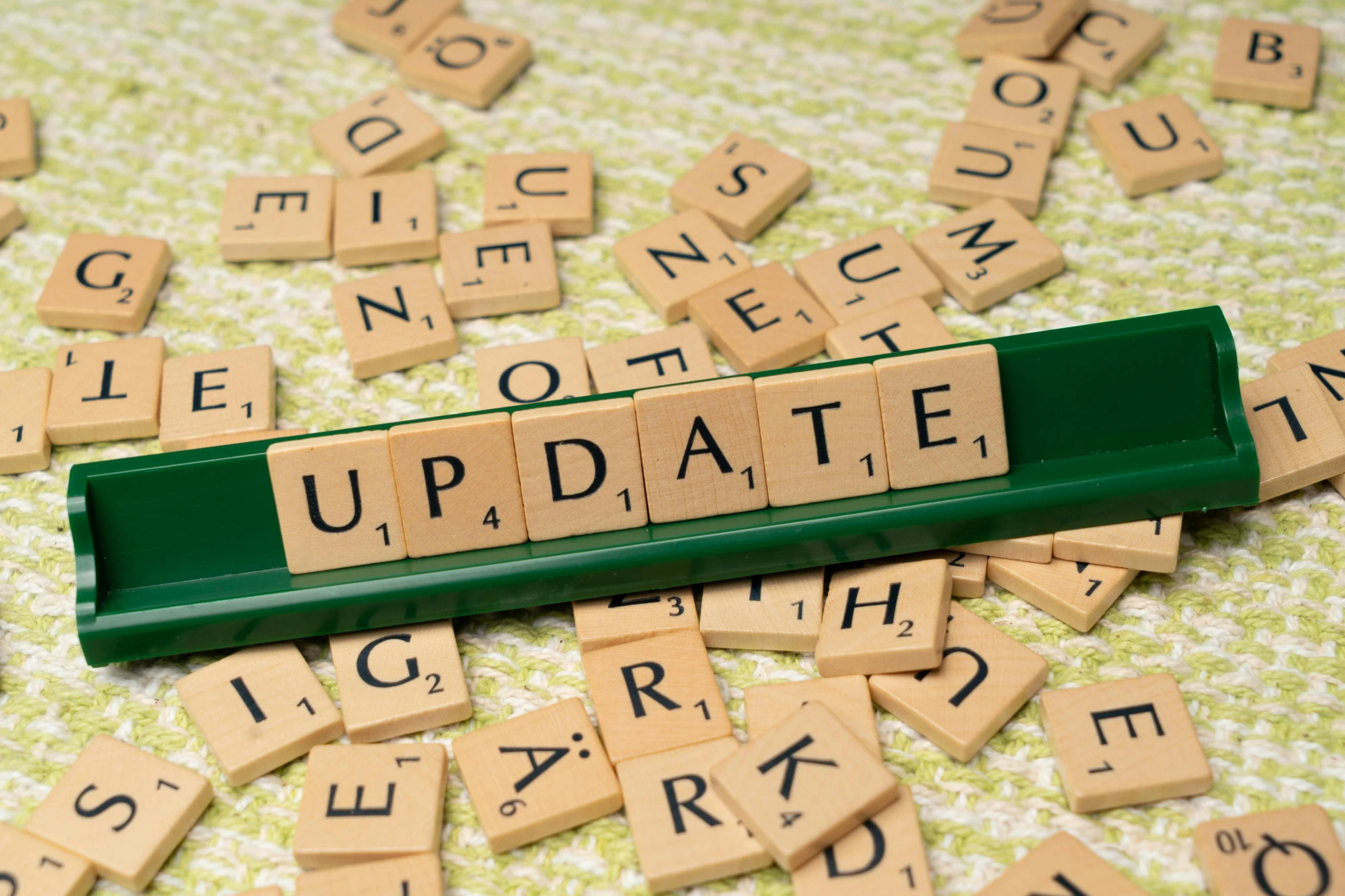 a keyboard with scrabble letters spelling the word updating