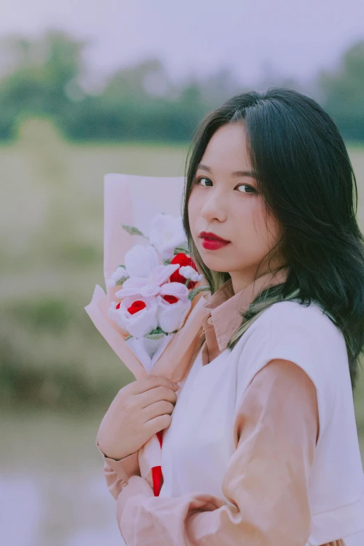 the woman is holding flowers close to her face