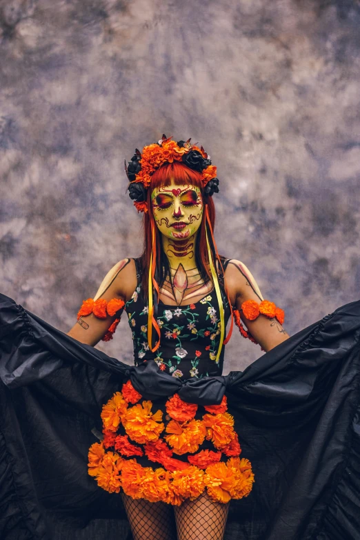 a woman with makeup and decorations poses while holding orange flowers