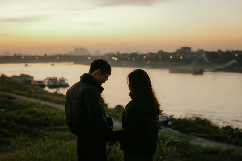 the two people are staring at the water