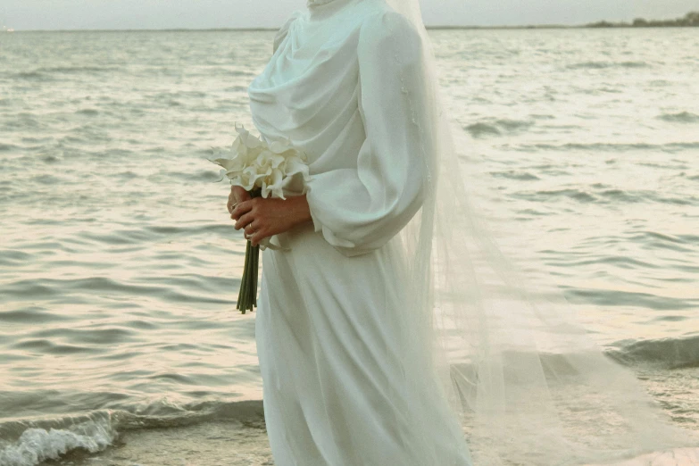 the young man is holding flowers near water