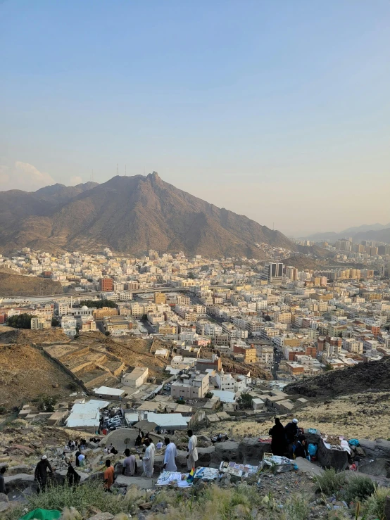 people camping out on top of the hill above the city