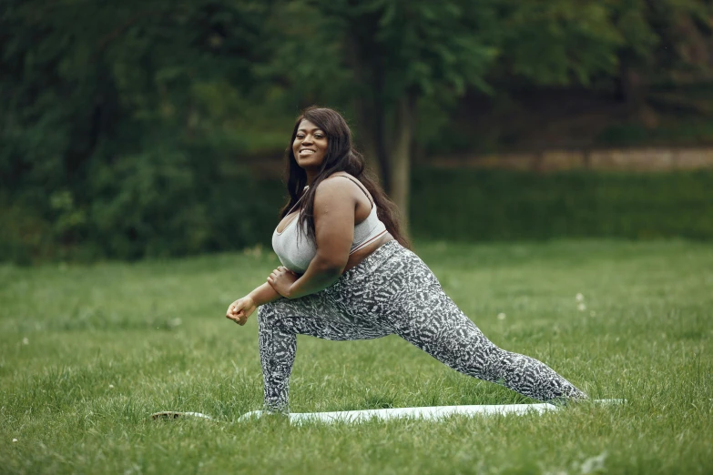 a woman practices yoga in the grass