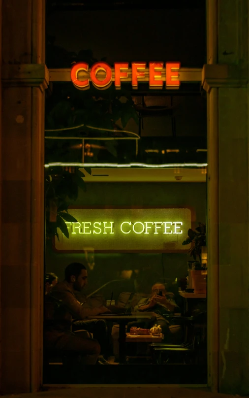 a neon sign that says coffee is lit up in the dark