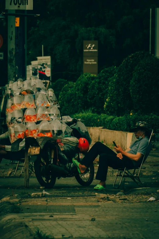 a man sitting on a bench near a motorcycle