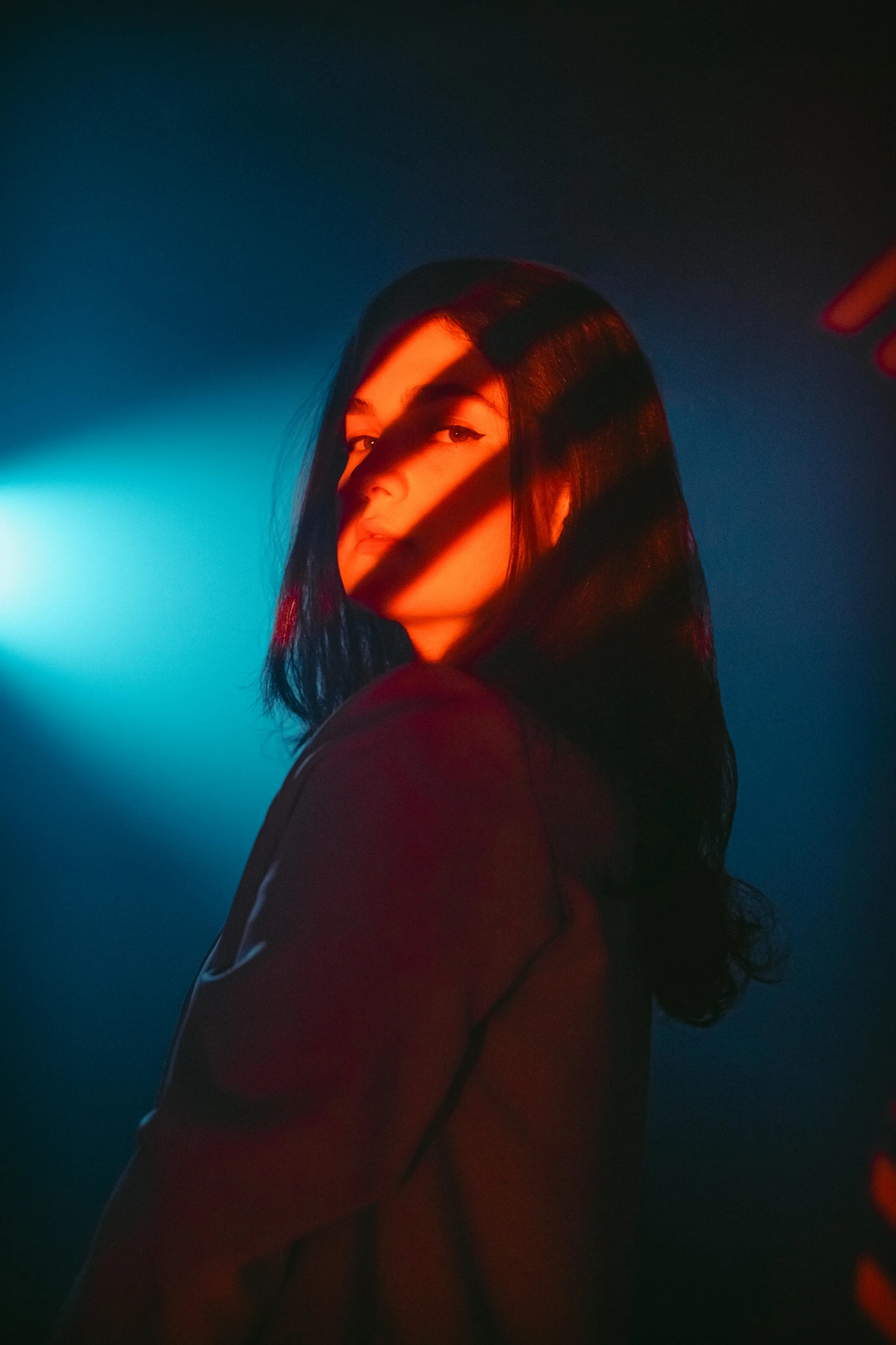 a person standing in front of a blue and green light