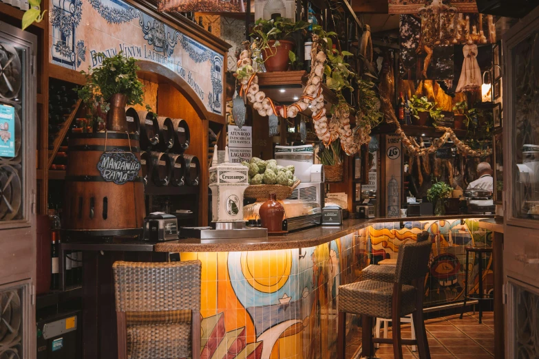 a small bar is filled with bottles and potted plants