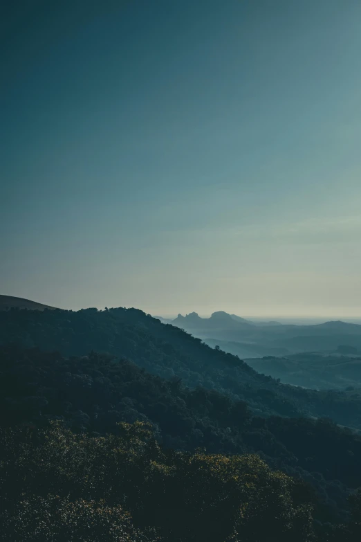 a view of mountains from a hill on a sunny day