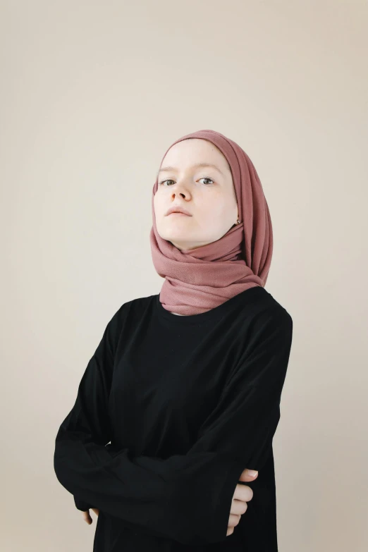 woman wearing a scarf standing with her hands folded