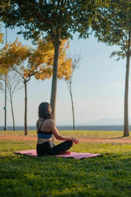 a woman is doing yoga in the grass