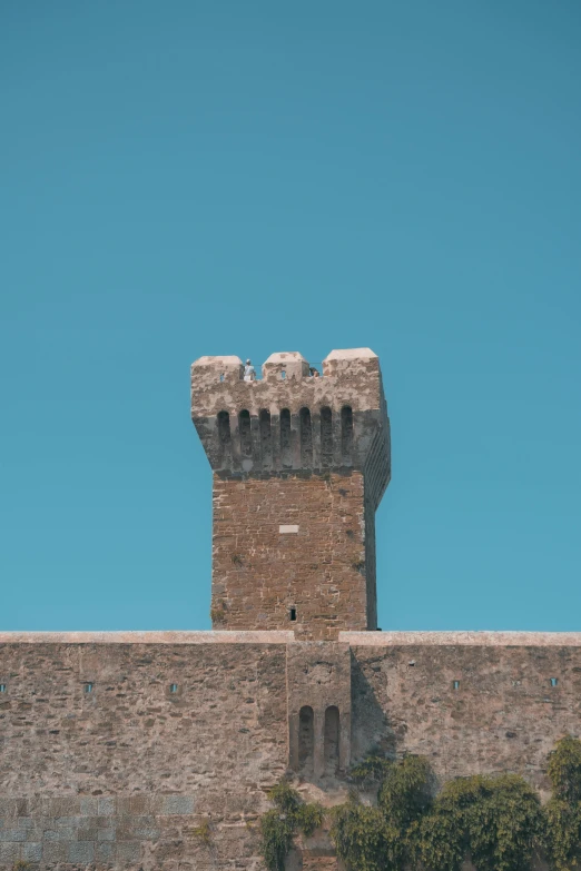 the top of a brick wall with a very tall clock