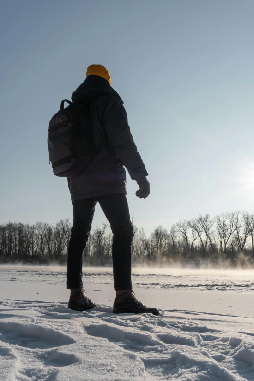 a person wearing a backpack while walking through the snow