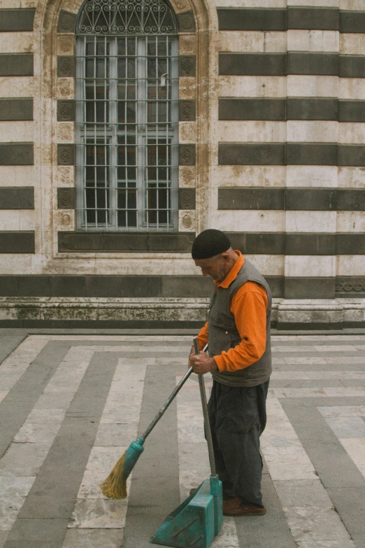 a man cleaning the road while holding a broom