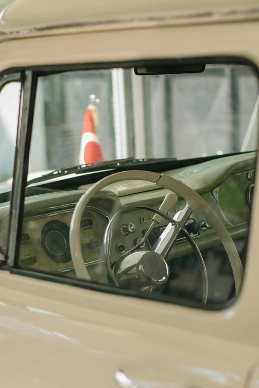 a view of the dashboard of a car with a red cone in the background