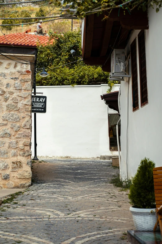 an old stone building is next to a white wall with a small building with windows