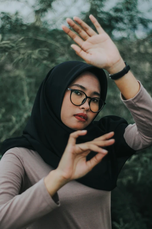 woman wearing hijab gesturing with palm up