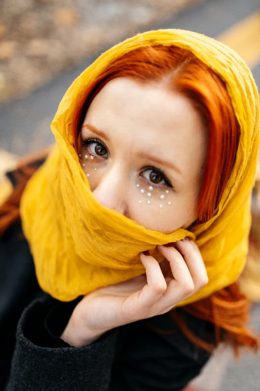 woman with bright red hair and a yellow scarf over her head