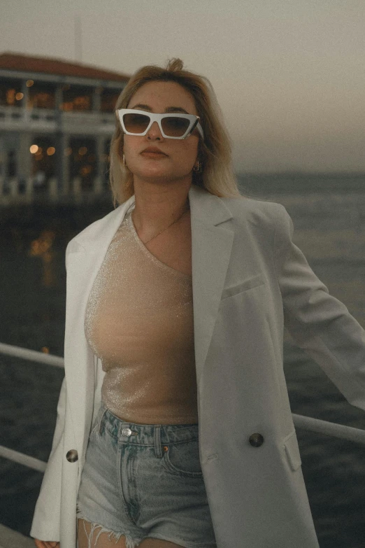 woman with sunglasses standing in front of a body of water