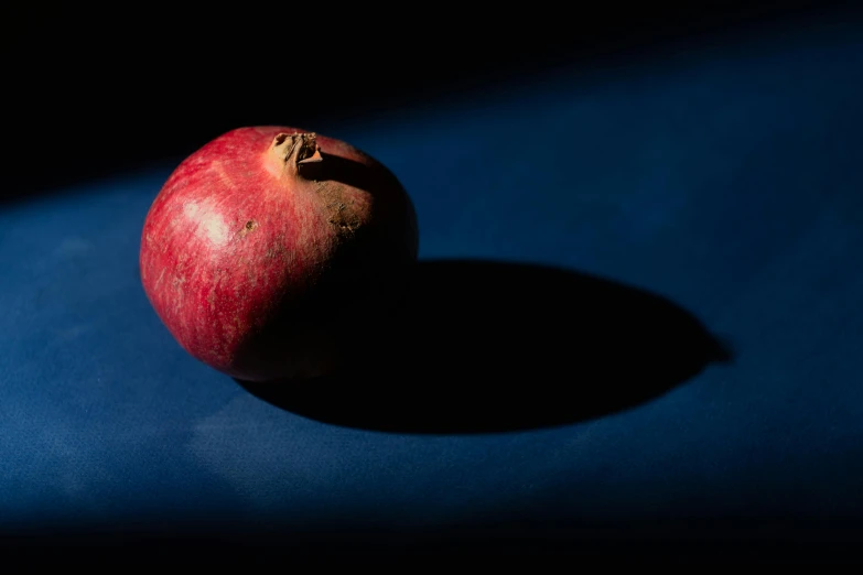 a red apple is sitting in the dark