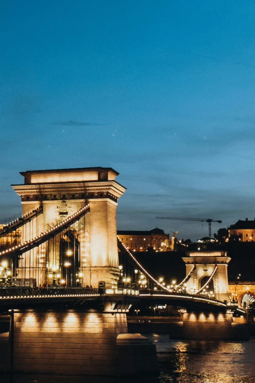 the very tall bridge is lit up at night