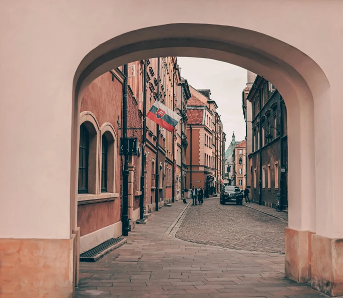 the narrow and crowded street has an archway leading into it