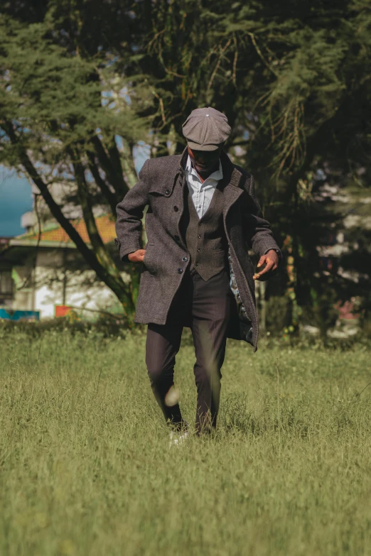 a man dressed in a suit walking through the grass