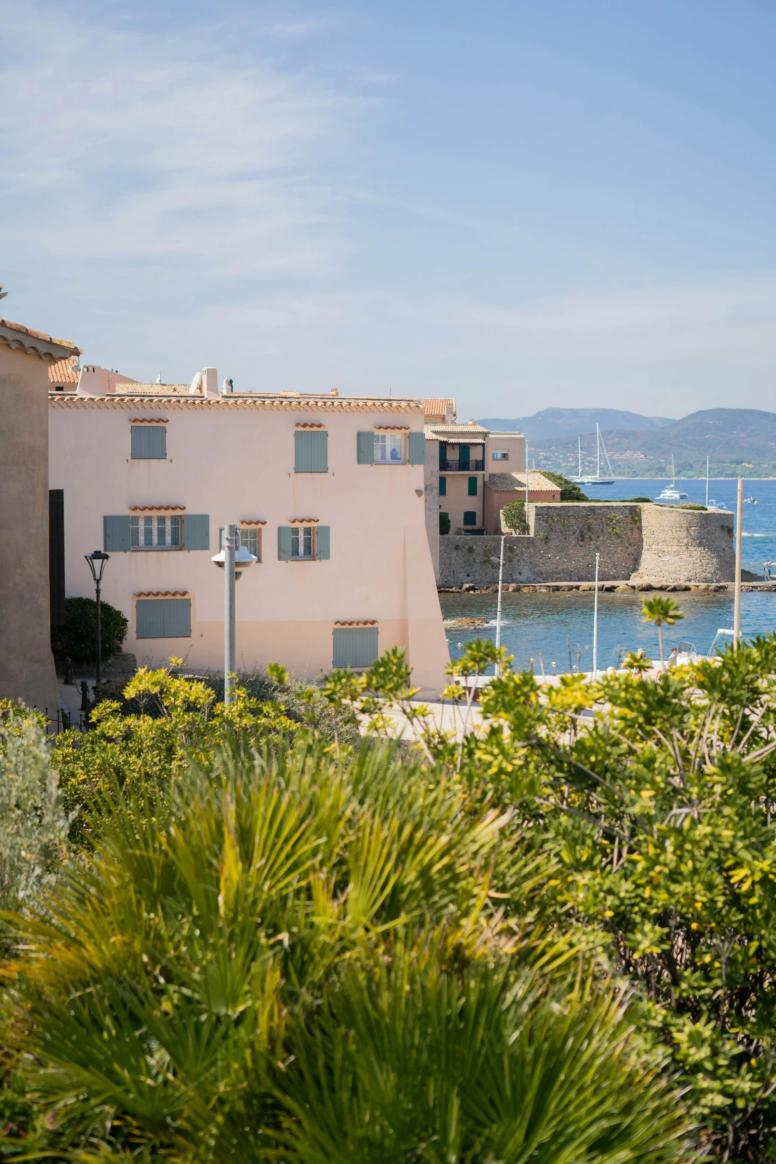 view of an apartment complex with ocean and greenery