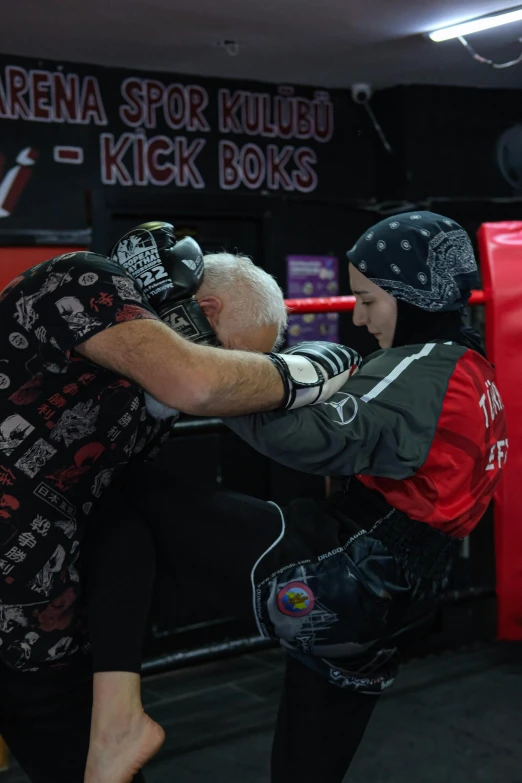 an older man wearing a helmet is punching another man with a boxing gloves