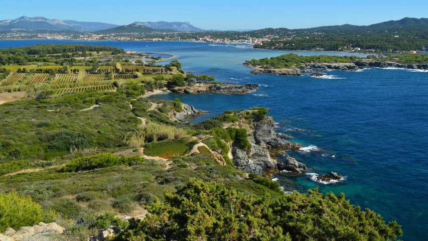 a blue body of water with a lush green hillside next to it