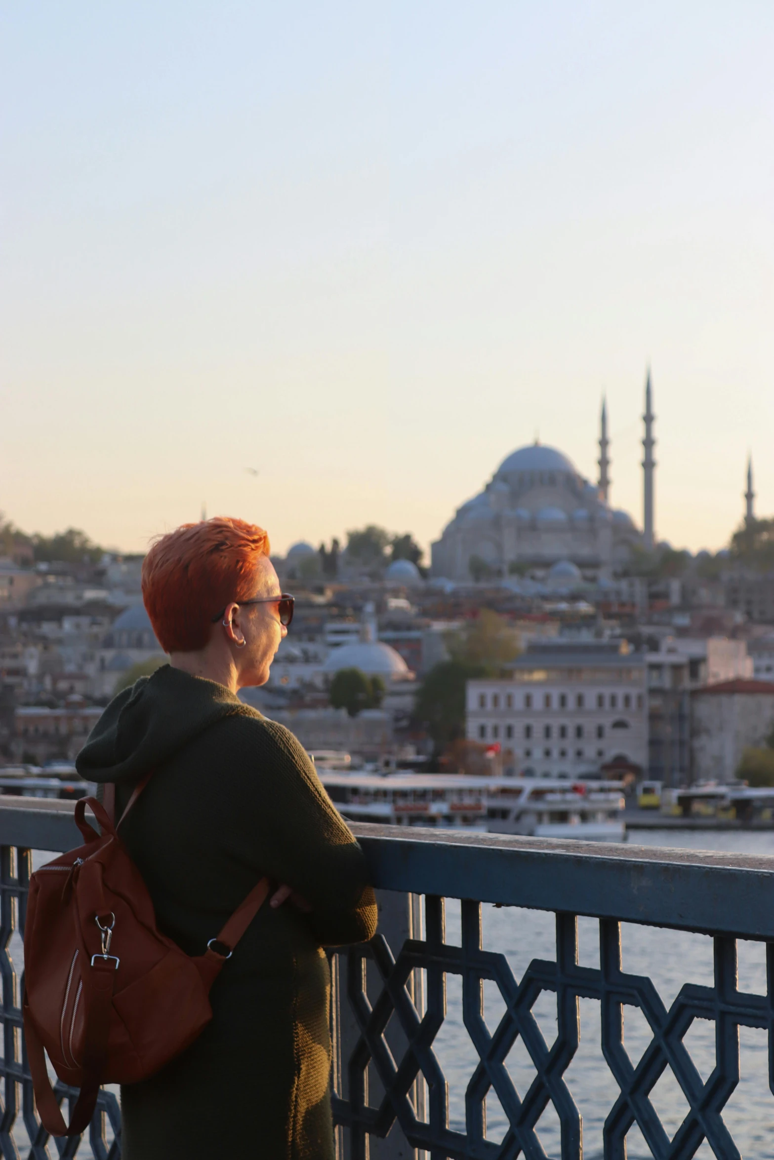 a woman with a red hair stares at the distant buildings