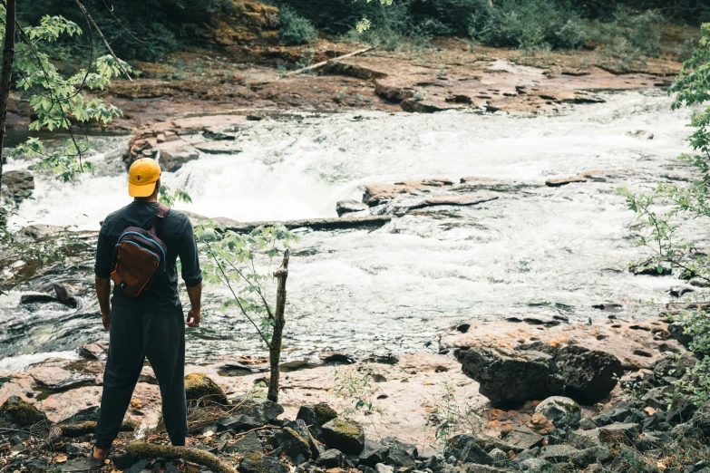 a man standing in front of a white river