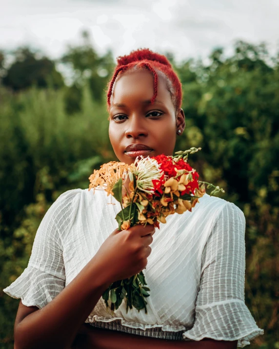 a woman holding a bouquet of flowers in her hands