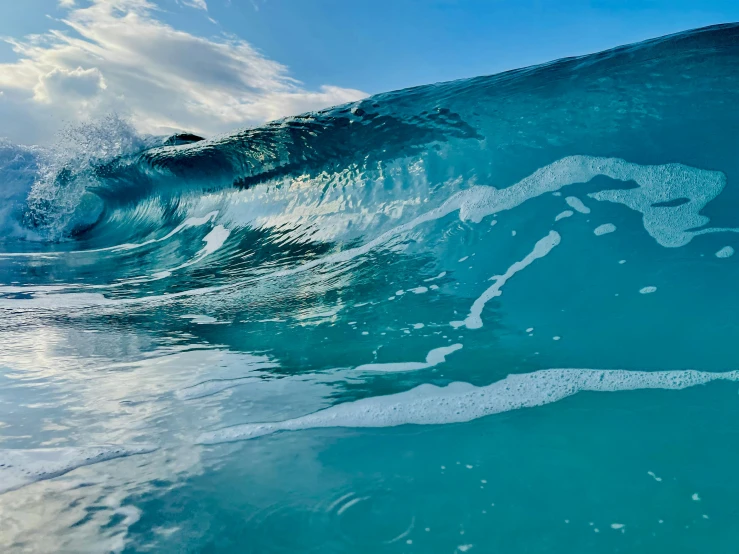 a wave is crashing over a blue body of water