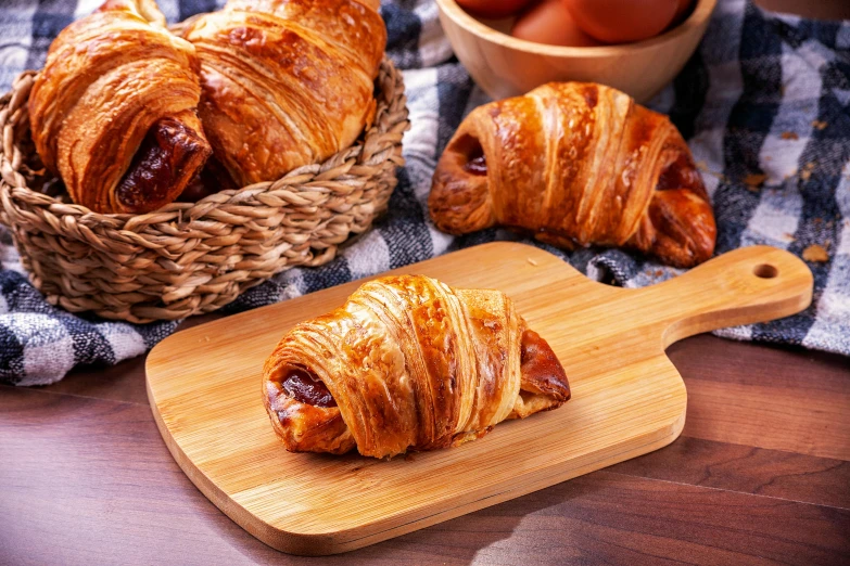 a couple of croissants and apples in a basket